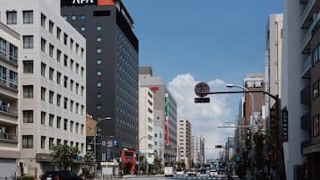 A multi-story hotel with a prominent APA sign, a pedestrian crossing, and a clear blue sky.