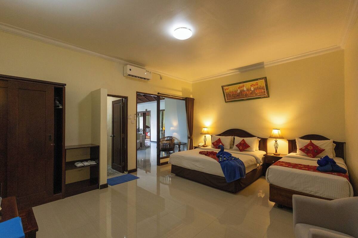 Een hotelkamer met twee bedden, een kast, een bureau en een stoel.