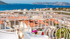 A balcony with a white railing overlooking a coastal town with red-roofed buildings and a view of the sea and mountains in the distance. - Kas Artemis Hotel (Kas)
