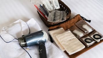 A Panasonic hair dryer, a basket with various hair care products, and a tissue box on a white surface.