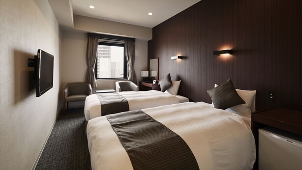 A hotel room with two beds, a desk, a chair, a flat-screen TV, and a window with curtains. - HOTEL AZAT Naha (Naha)