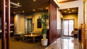 A lobby with a reception desk, seating area, and a staircase. - HOTEL AZAT Naha (Naha)