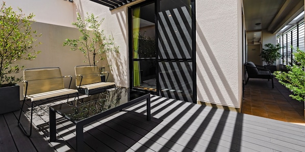 Relax and socialize in this serene outdoor seating area, featuring a glass-top table and comfortable metal chairs on a spacious deck.
