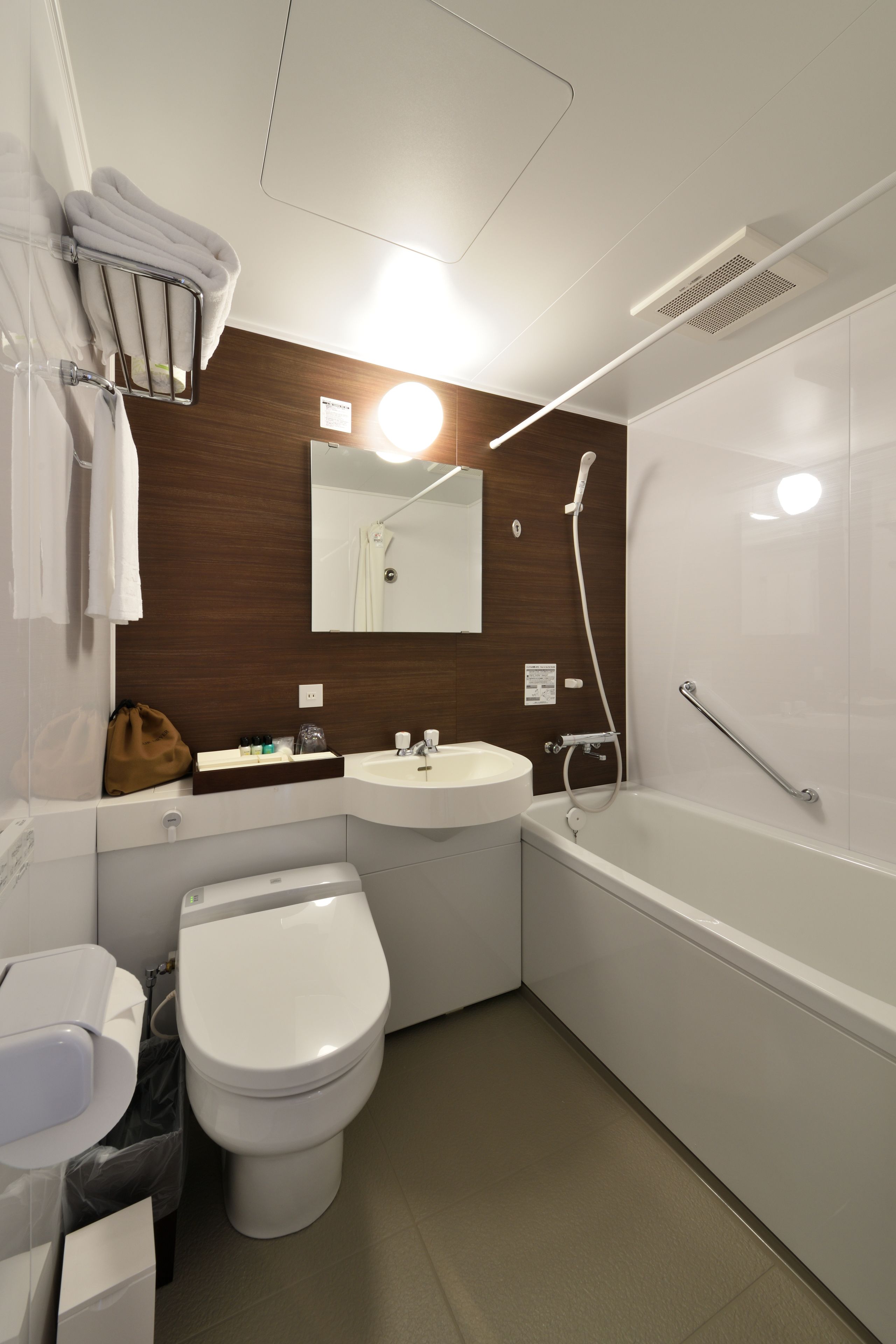Een moderne badkamer met toilet, wastafel en bad.