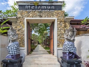 The entrance to Melamun Hotel & Chocolate Spa with a stone facade and two statues on either side. - Hotel Melamun (Buleleng)