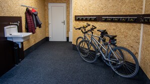 Une salle de bain avec un lavabo, une porte et un porte-vélo sur lequel est appuyé un vélo.