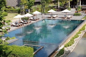Relax by the pool surrounded by lounge chairs and umbrellas on a clean, tiled deck.