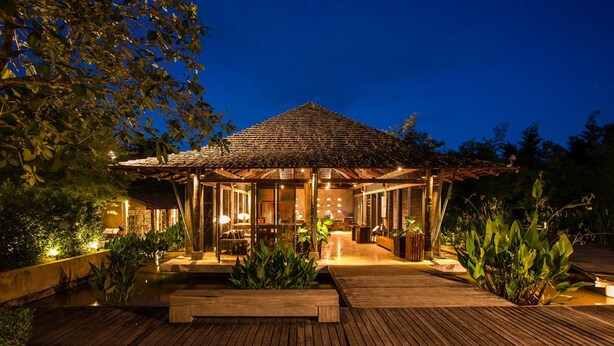 A wooden deck leading to a covered outdoor area with seating and a pool. - Kirimaya Golf Resort Spa (Pak Chong)