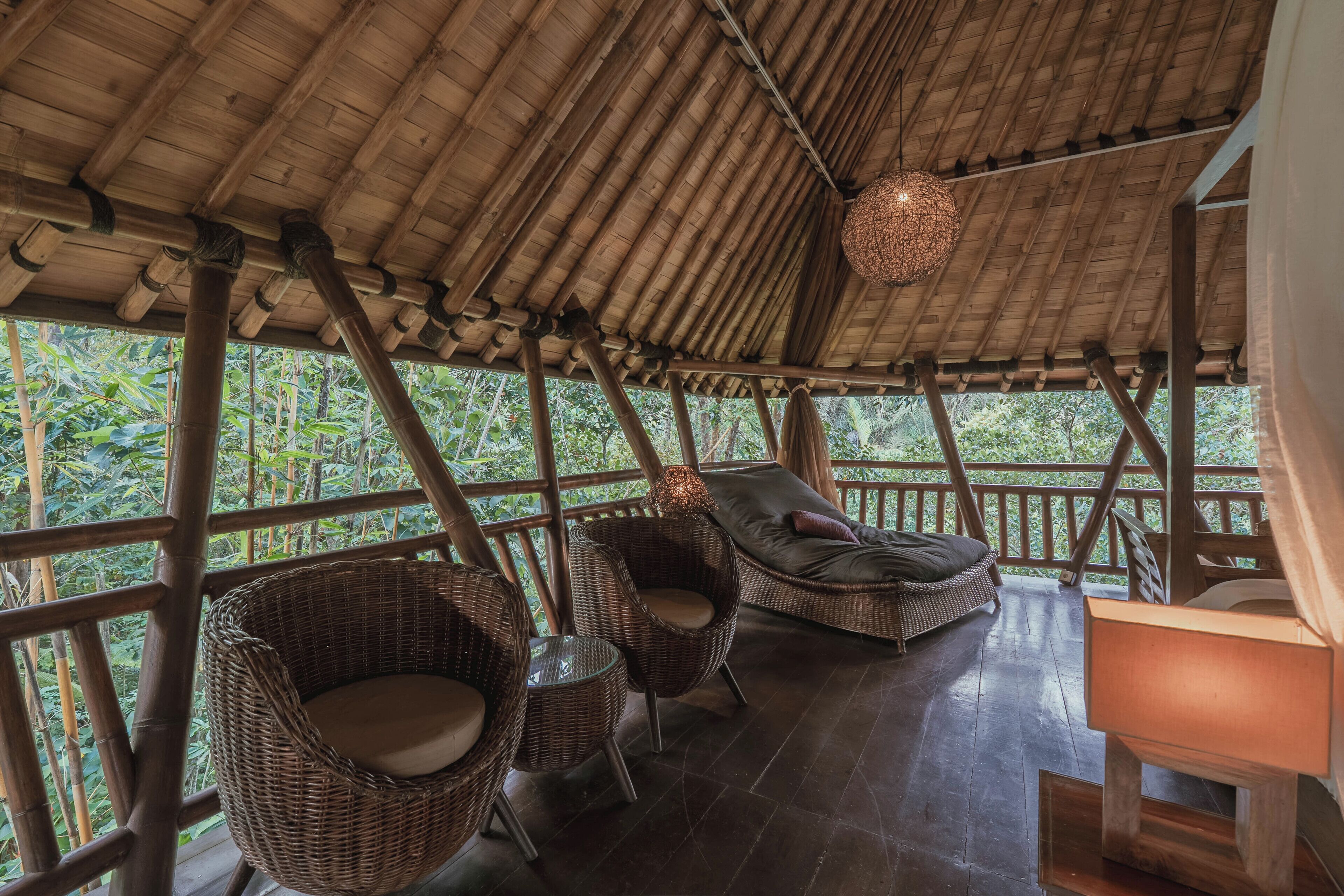 A wooden deck with wicker furniture and a hanging light fixture.