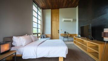Une chambre moderne avec un grand lit, un bureau, une télévision et une fenêtre.