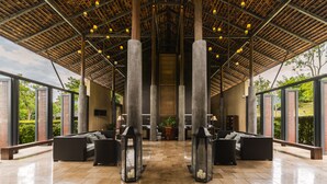 A spacious lobby with high ceilings, large pillars, and modern seating areas. - MUTHI MAYA Forest Pool Villa Resort (Pak Chong)