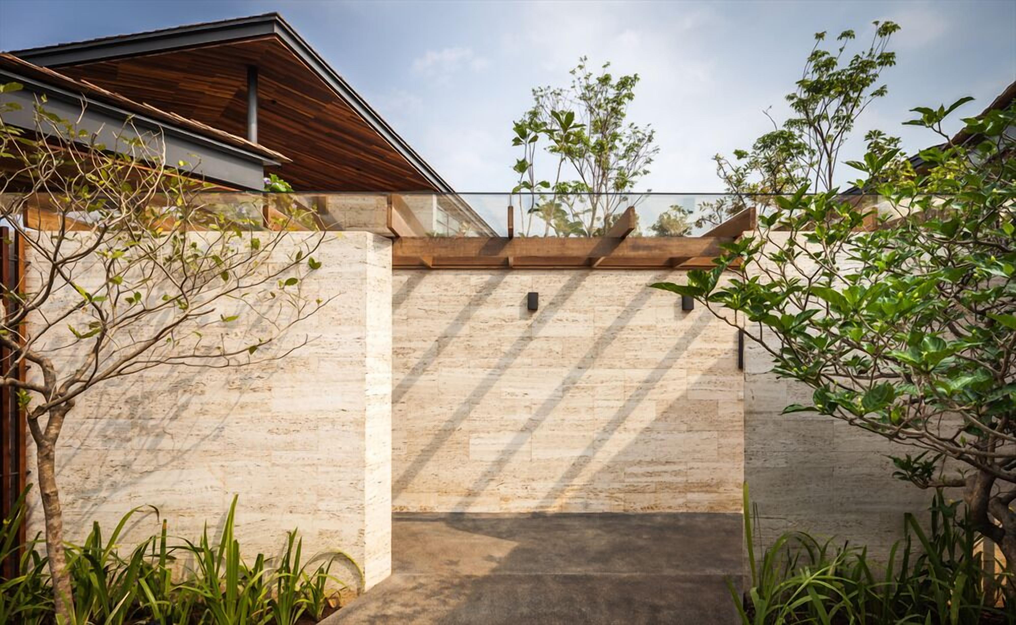 A modern building with a stone facade, a wooden roof, and a clear sky.