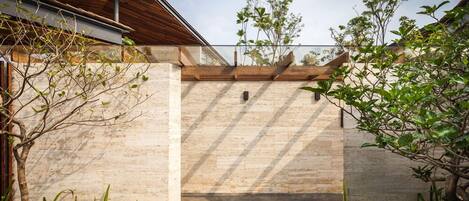 A modern building with a stone facade, a wooden roof, and a clear sky.
