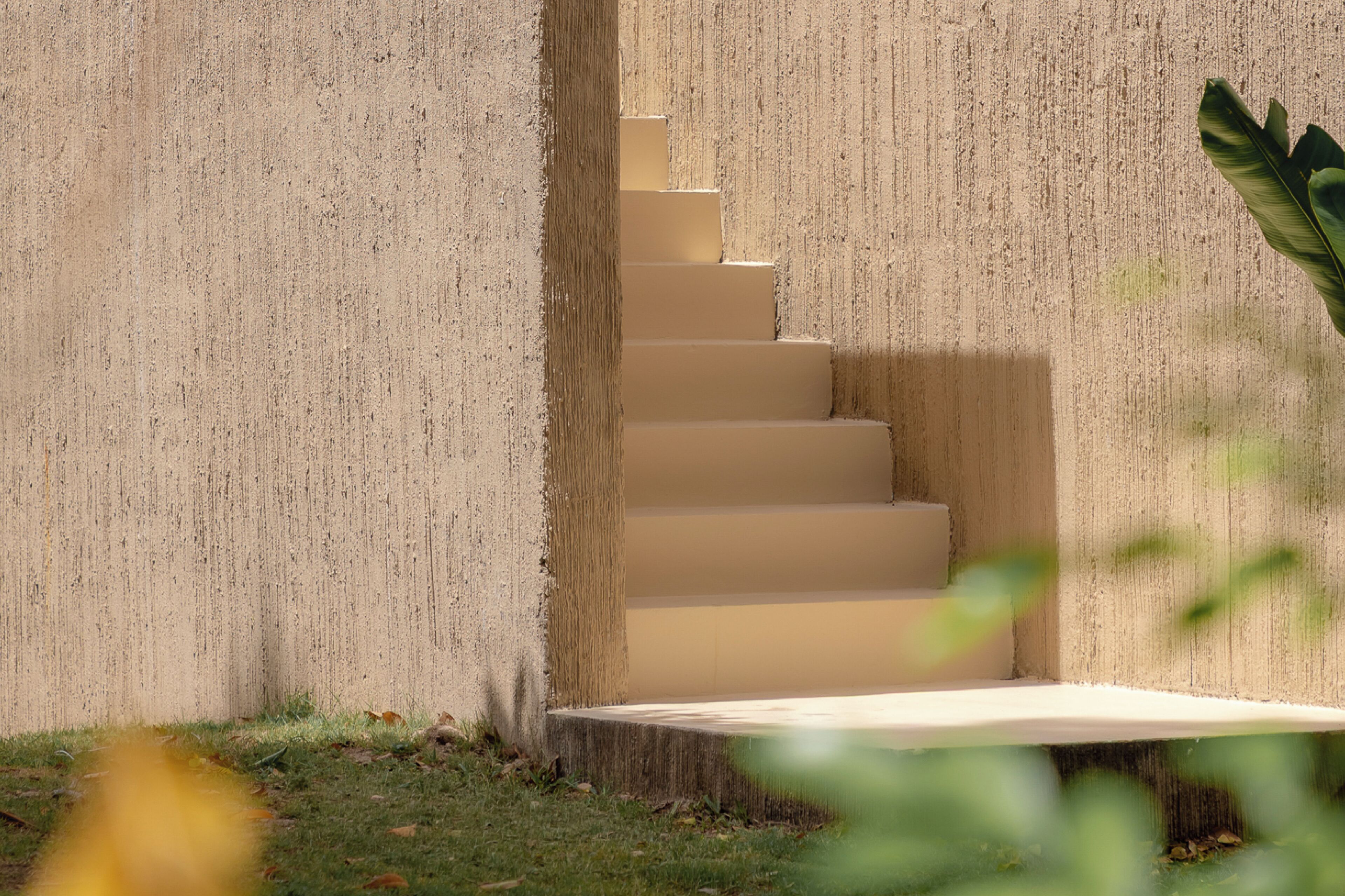Eine Betontreppe führt zu einem Hauseingang.
