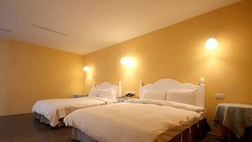 Une chambre d’hôtel avec deux lits, une table de chevet et des lampes fixées au mur.