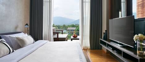 A hotel room with a large bed, a flat-screen TV, and a view of the outdoors.