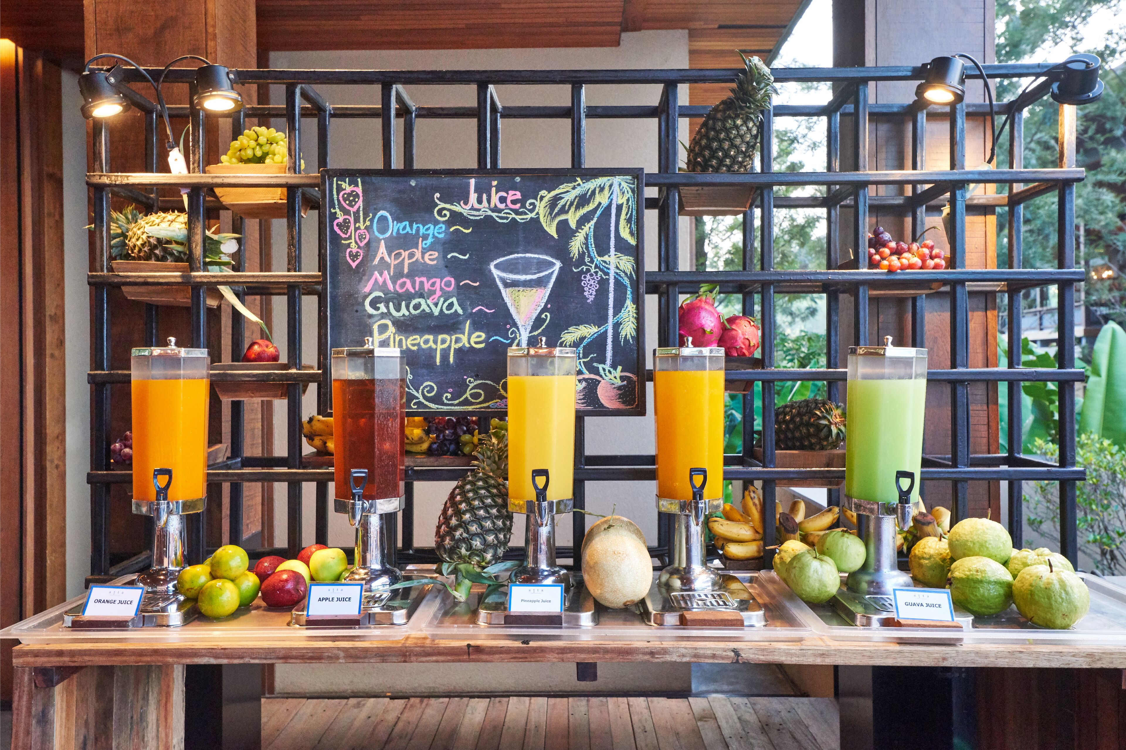 A juice bar with various fruit options and a chalkboard menu listing juice types.