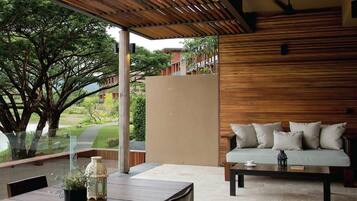 Un espace extérieur moderne, aménagé avec un plafond en bois et une paroi vitrée donnant sur un jardin.