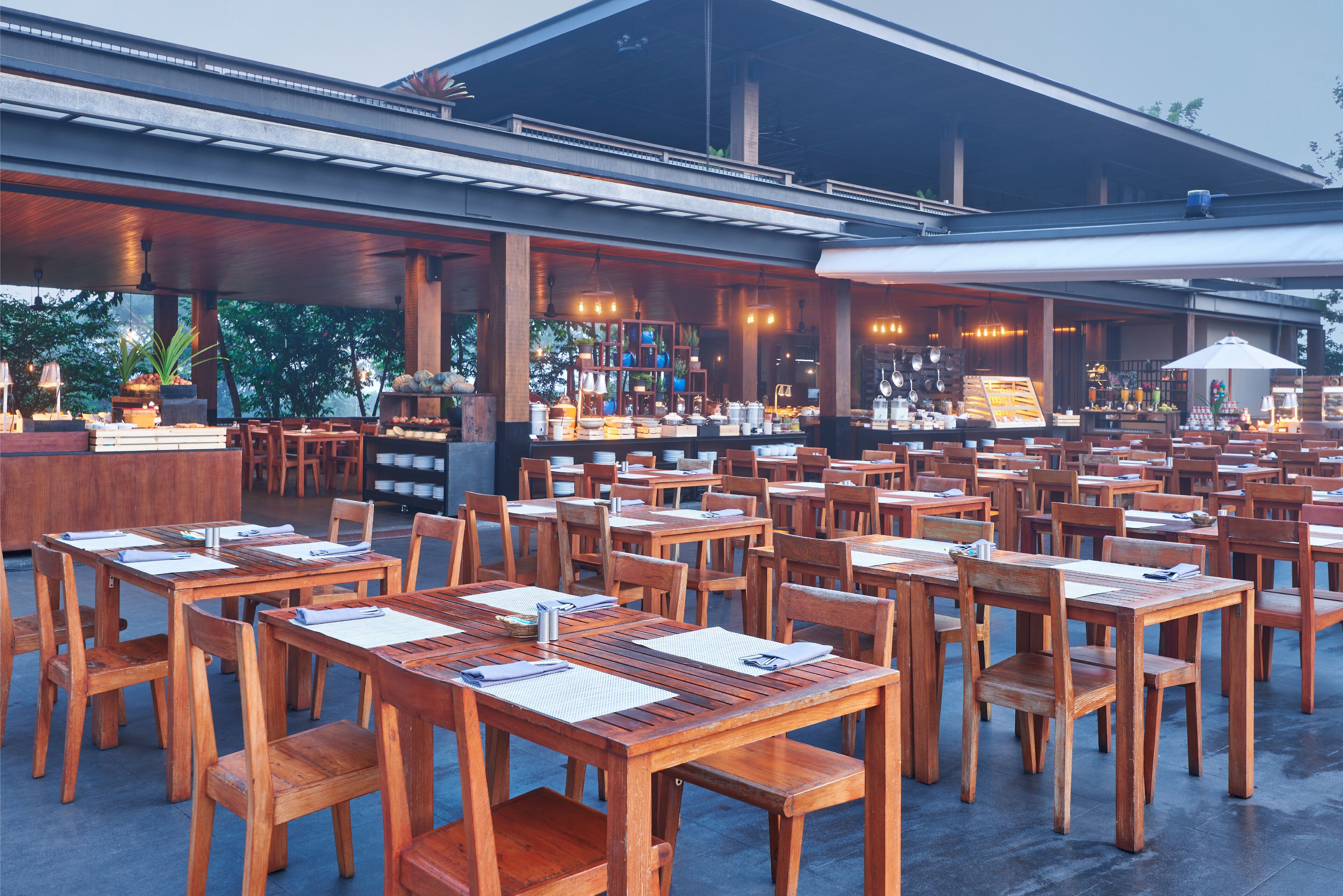 A restaurant with wooden tables and chairs, a bar area, and a view of the outdoors.