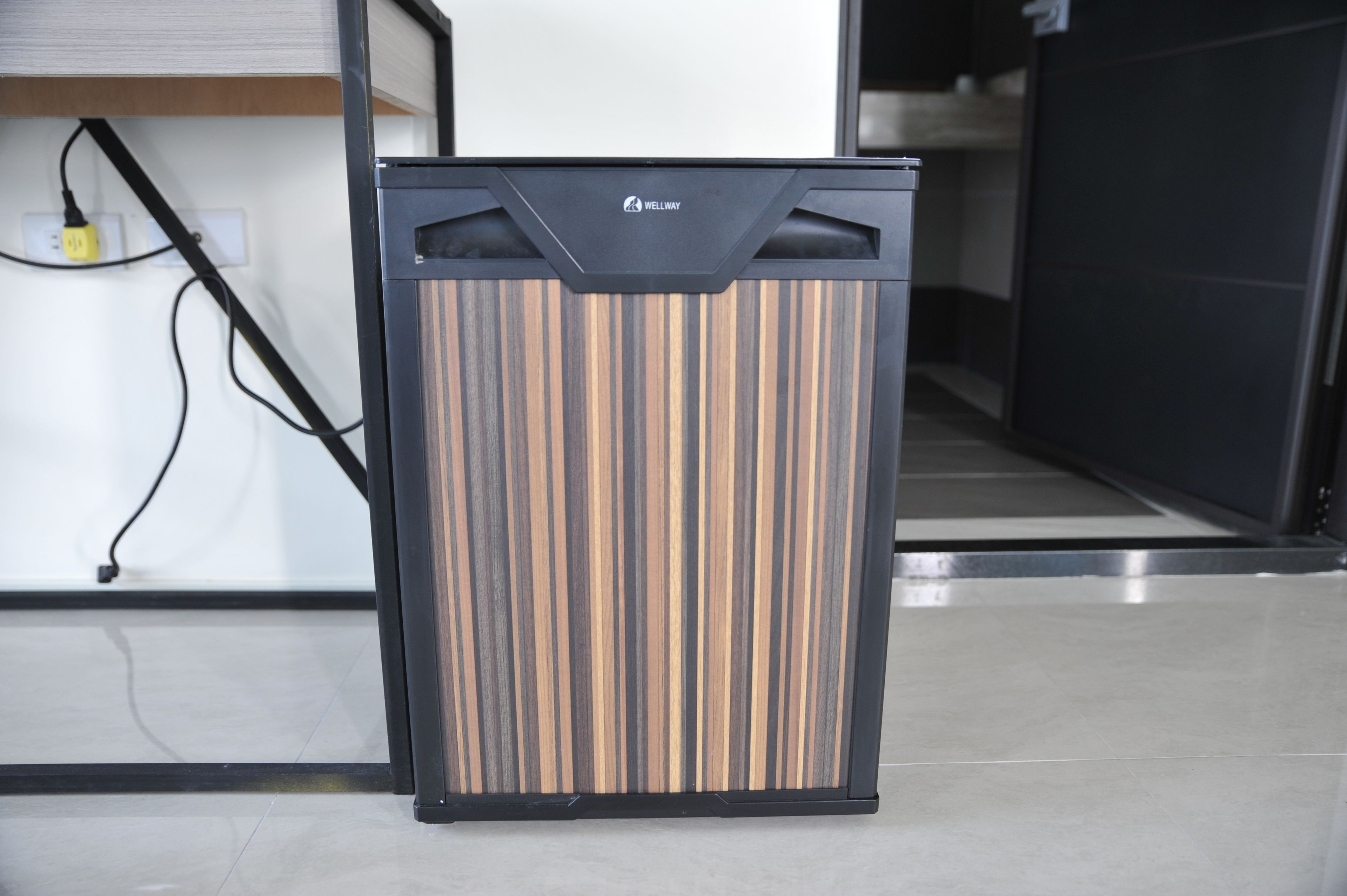 A modern, black-framed, vertical cabinet with a wood grain pattern, labeled "WELLWAY."