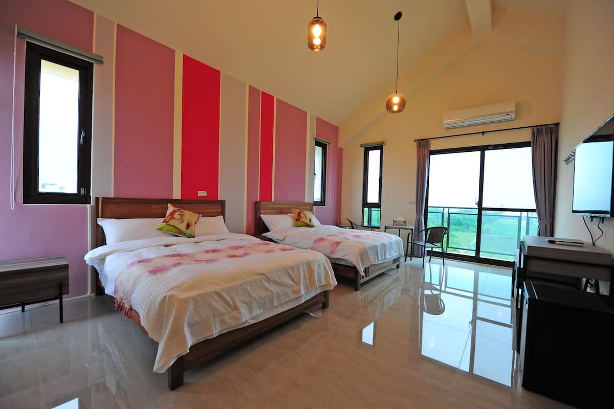 A hotel room with two beds, a balcony, and an air conditioning unit.