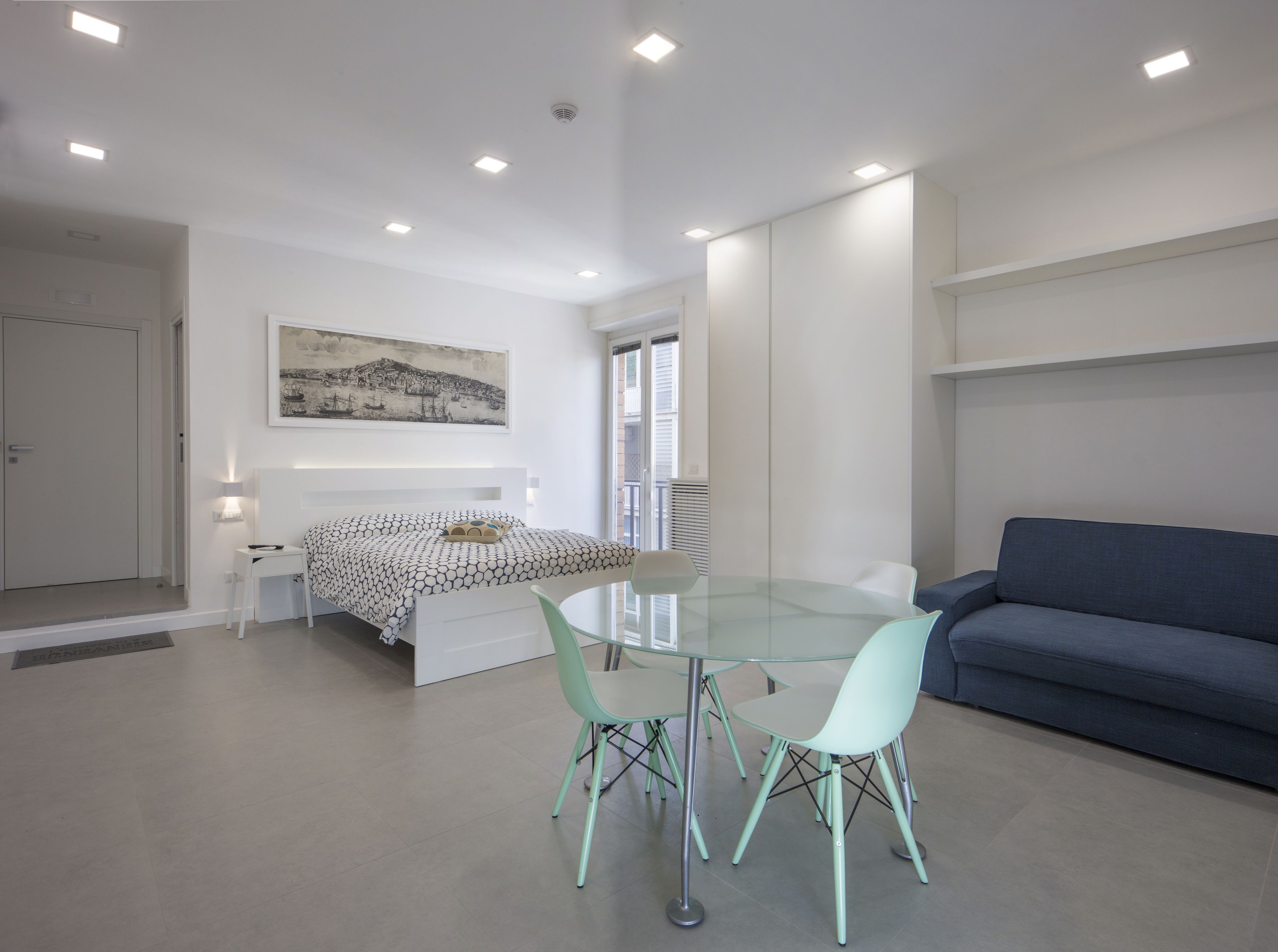 Un dormitorio moderno con cama, mesita de noche y un cuadro en la pared.