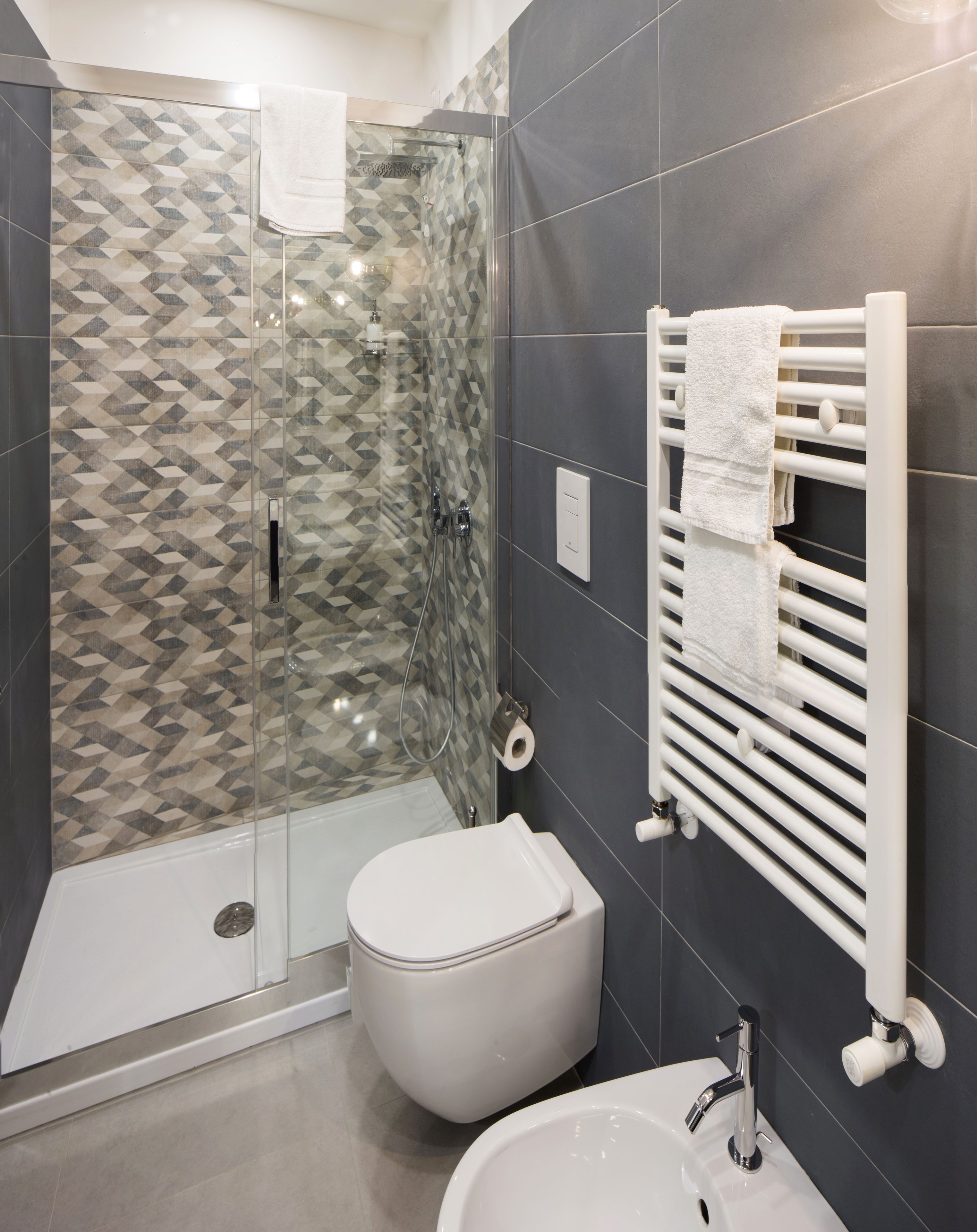 A modern bathroom with a glass shower enclosure, a toilet, and a sink.