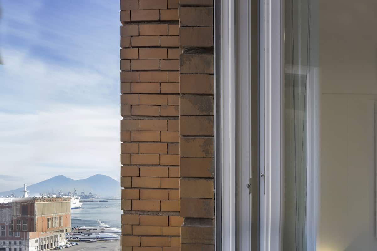 A balcony with a view of a busy street and a large ship in the distance.