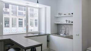 Een moderne keuken met een groot raam, een spoelbak en twee krukken.