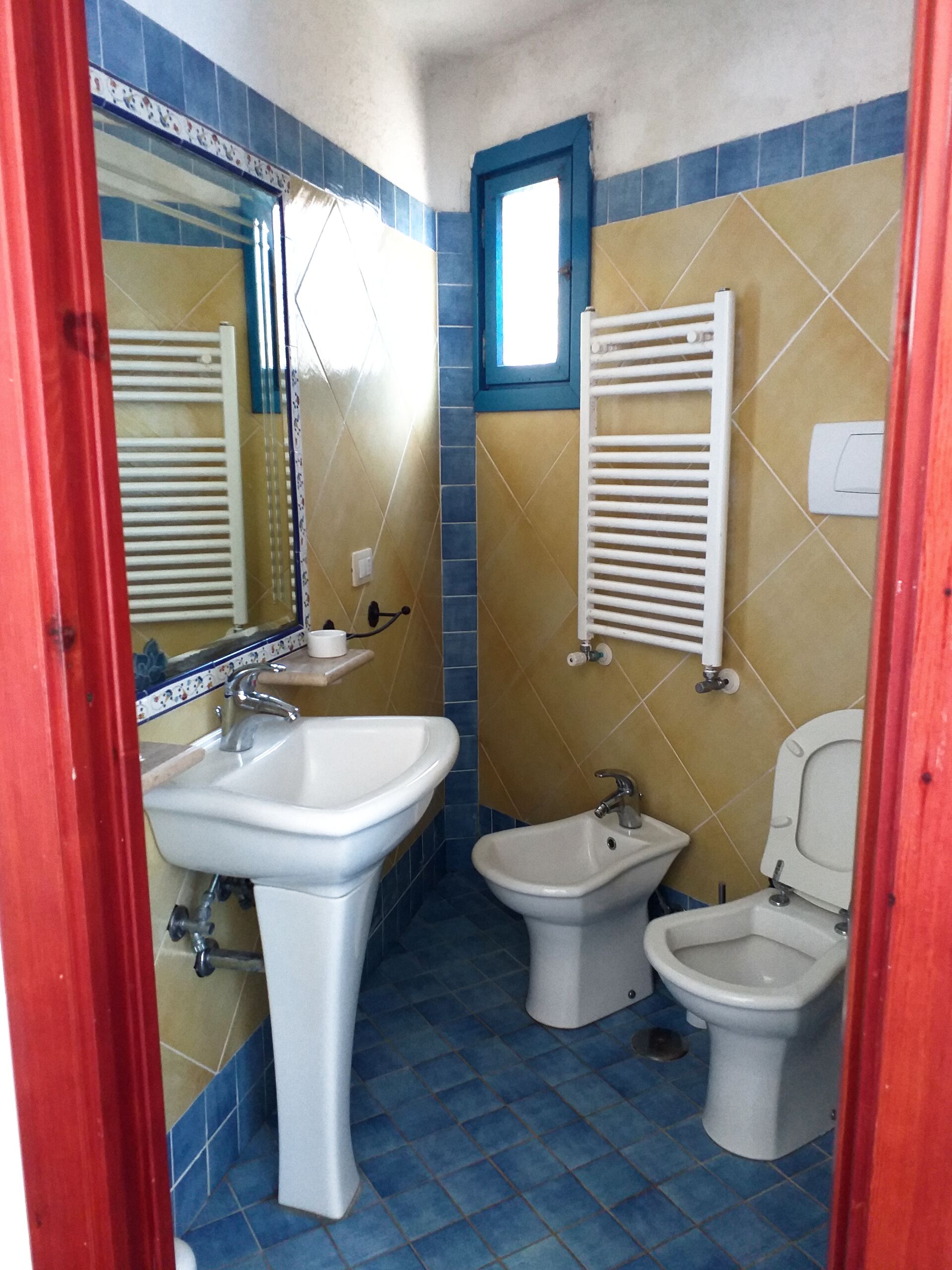 Un bagno con lavabo su piedistallo, bidet e water.