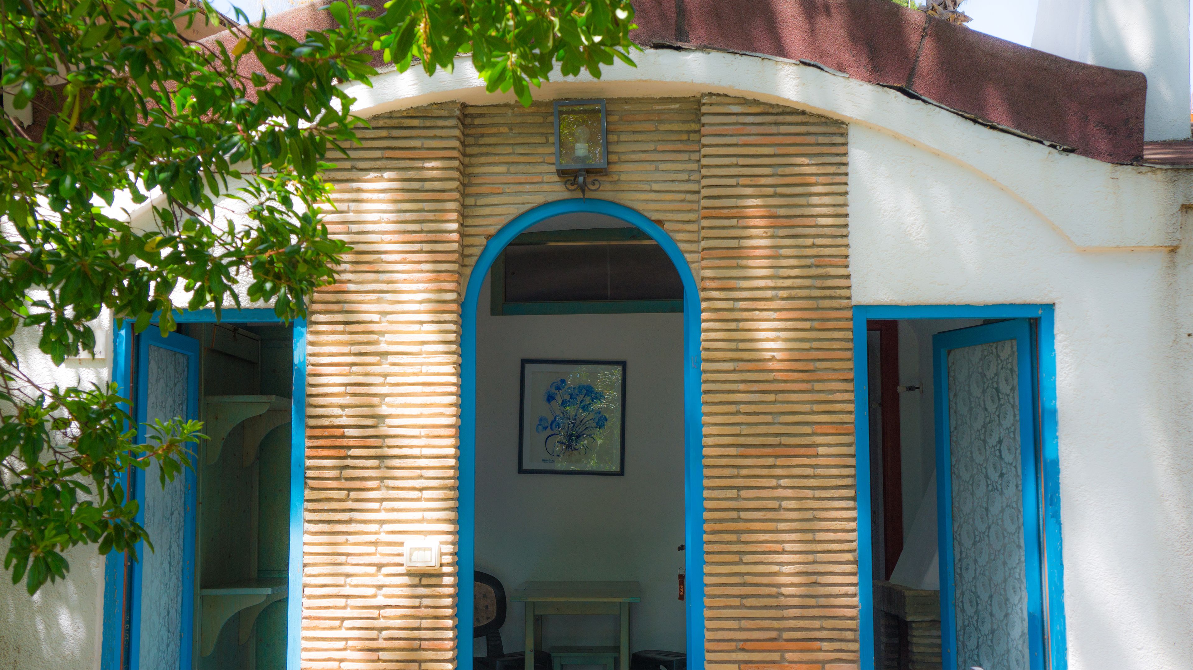 Ein Gebäude mit einer Ziegel Fassade, einem blauen Bogen und einem gerahmten Bild an der Wand.