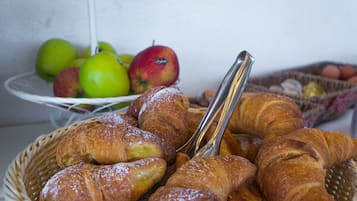 Un cesto con croissant e mele.