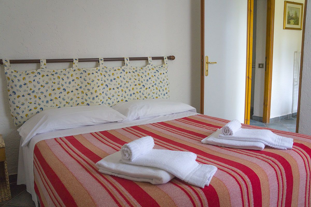 Une chambre d’hôtel avec un lit, des oreillers et des serviettes.