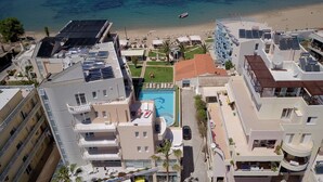 Un hotel de gran altura con piscina en la azotea, vista a la playa y paneles solares.