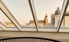 A view from a window with a metal railing, overlooking a building with a prominent tower and dome. - Wyndham Grand Krakow Old Town (Kraków)