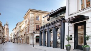 A street view with a building labeled "Trattoria Degusti" and "Wyndham Grand" on the corner.