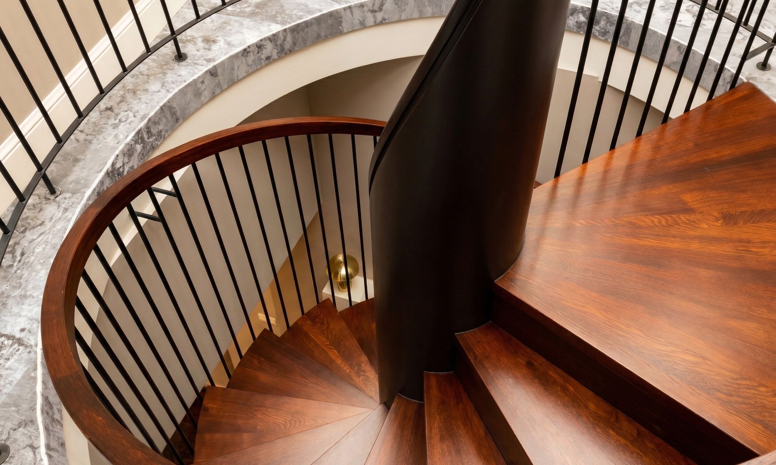A spiral staircase with a wooden finish and metal railings.