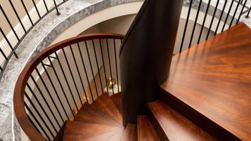 A spiral staircase with a wooden finish and metal railings.