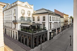 A multi-story building with a café on the ground floor, featuring large windows and outdoor seating. - Wyndham Grand Krakow Old Town (Kraków)