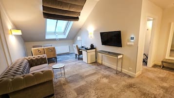 A modern living room with a sofa, a desk, and a TV.