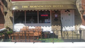 The Mornington Hotel with a red awning, a signboard, and a visible entrance door. - The Mornington Hotel (Blackpool)