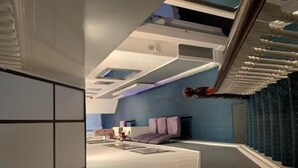 A modern hotel room with a unique architectural design, featuring a sloped ceiling, a built-in staircase, and a large window providing a view of the cityscape. - The Mornington Hotel (Blackpool)