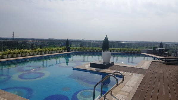 Piscina en la azotea con una vista despejada del paisaje urbano de fondo.