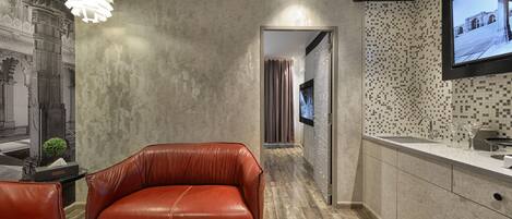 Una cocina moderna con televisor integrado, un sofá de cuero y una pared decorativa.