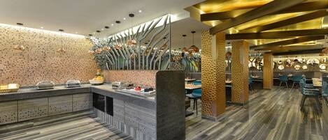 A modern restaurant interior with a central island, seating areas, and decorative lighting.
