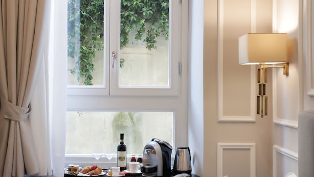 Et værelse med et vindue, et bord med morgenmad, en lampe og en sofa.