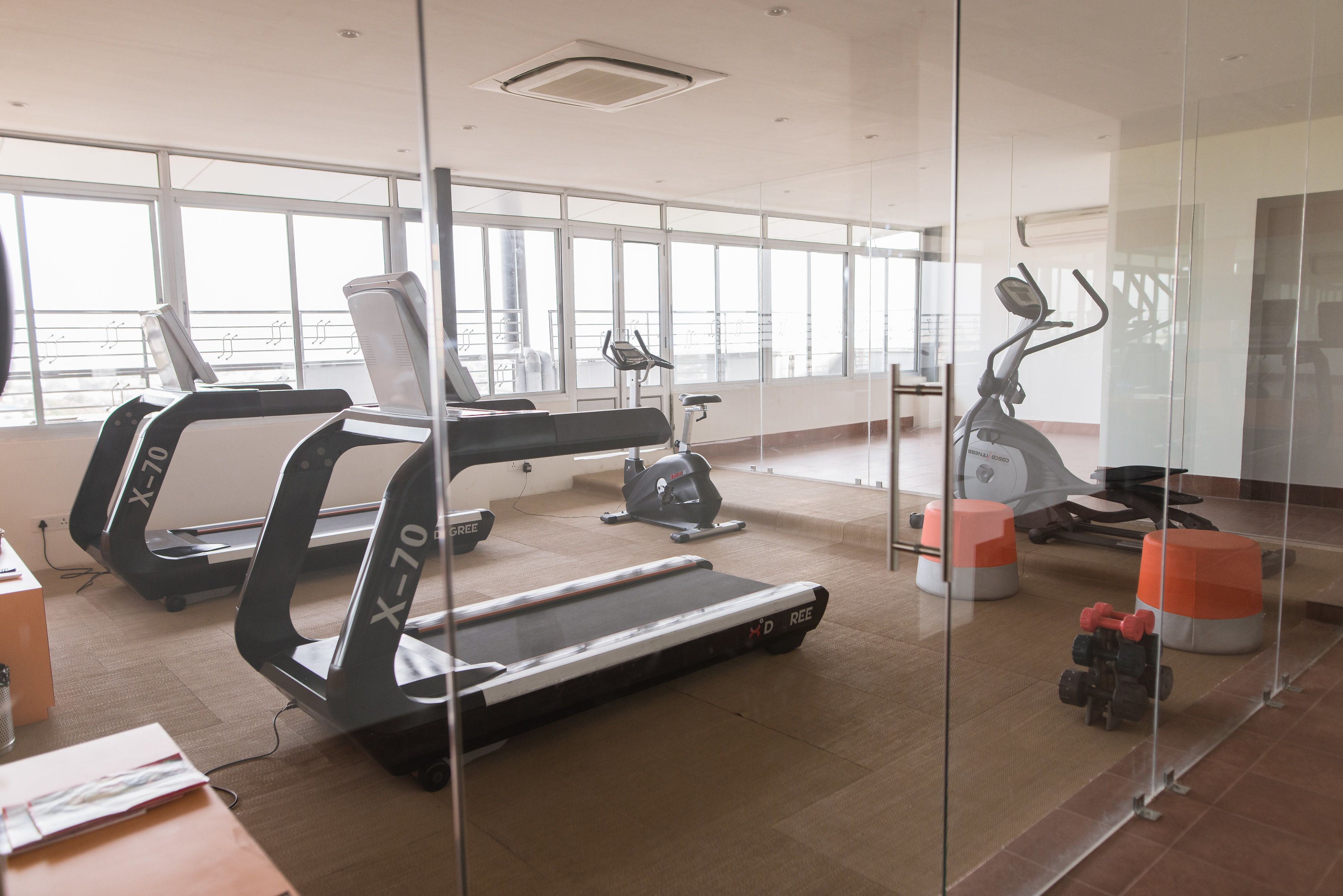 Un gimnasio con cintas de correr, elípticas y mancuernas.