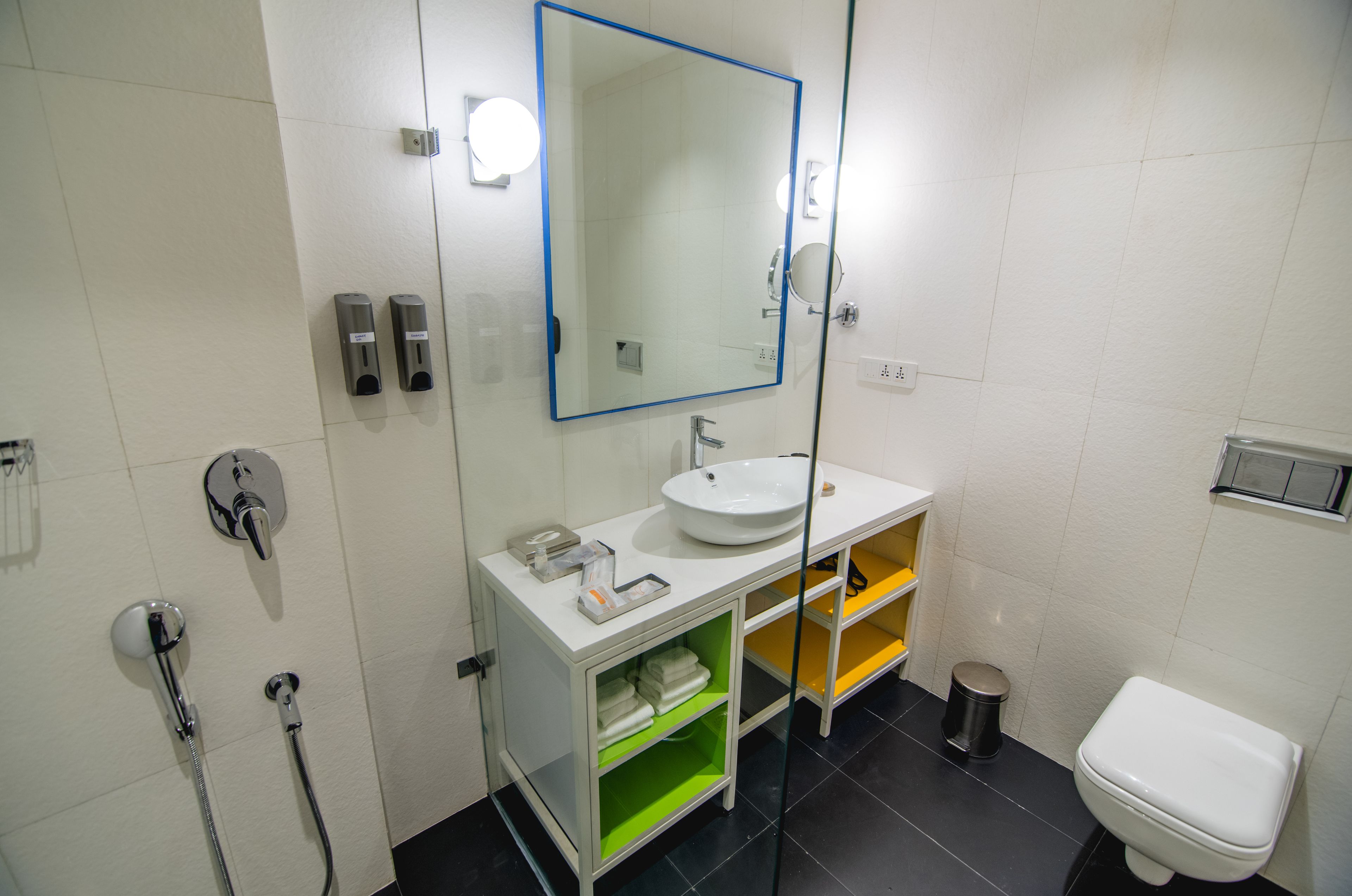 A modern bathroom with a white sink, mirror, and toilet.