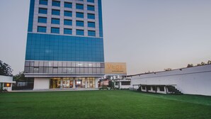 Un edificio moderno con un amplio frente de vidrio y un letrero que dice "Vega by the ozone hotels".
