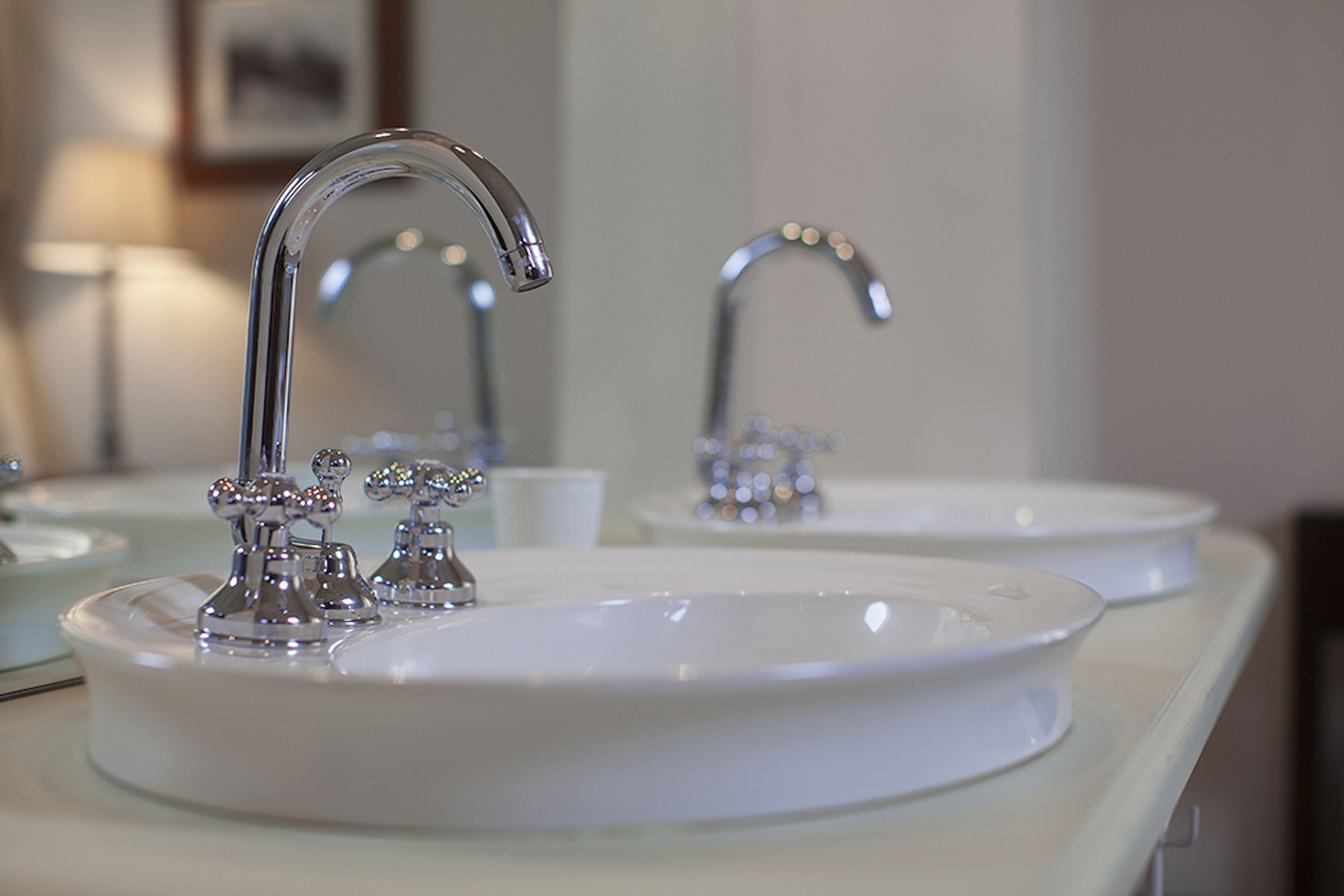 Une salle de bain avec deux lavabos, chacun doté d’un robinet chromé et d’une cuve blanche.